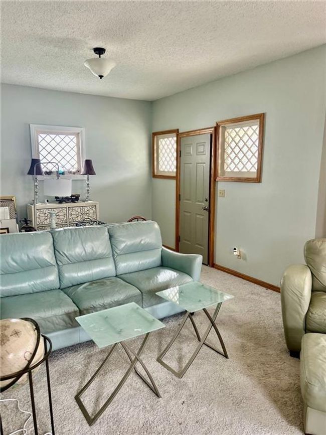 Living area featuring carpet floors, baseboards, and a textured ceiling | Image 9