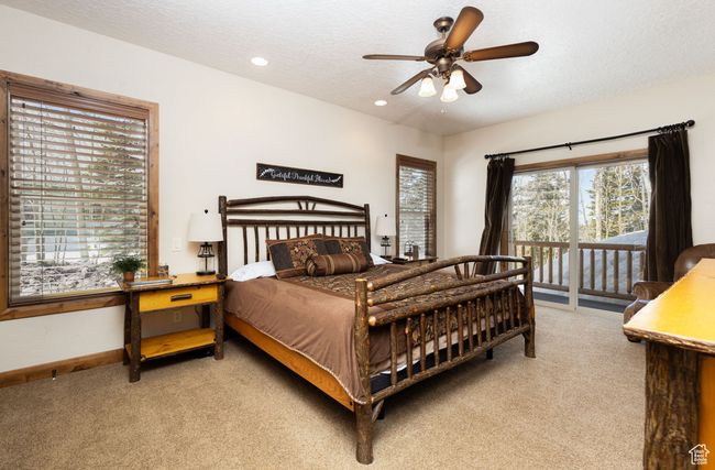 Bedroom featuring a textured ceiling, baseboards, access to outside, recessed lighting, and light colored carpet | Image 29