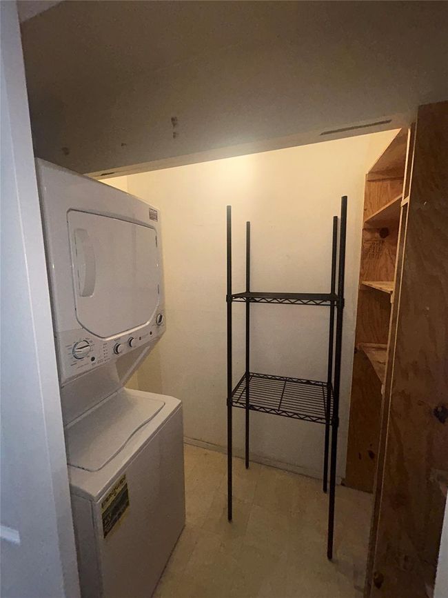 Laundry area with stacked washing machine and dryer and light floors | Image 12