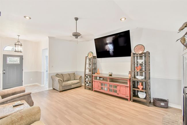 Living area with wood finished floors, recessed lighting, a chandelier, and a ceiling fan | Image 31