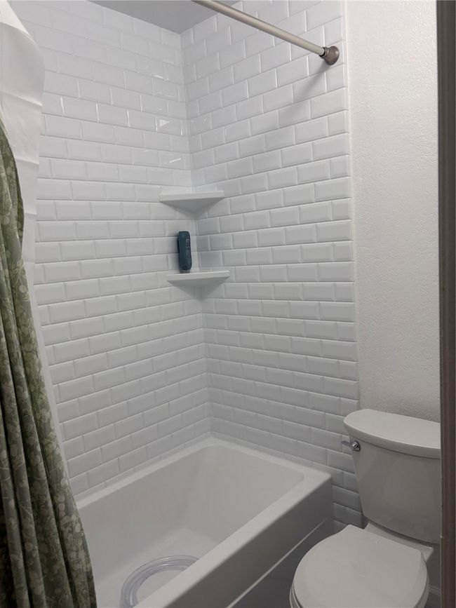 Full bathroom featuring shower / bath combination with curtain and toilet | Image 9