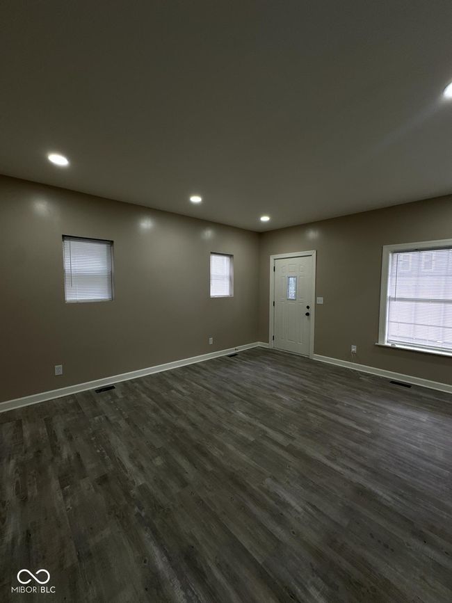 Unit 1 - unfurnished living room with dark wood-style flooring and recessed lighting | Image 8