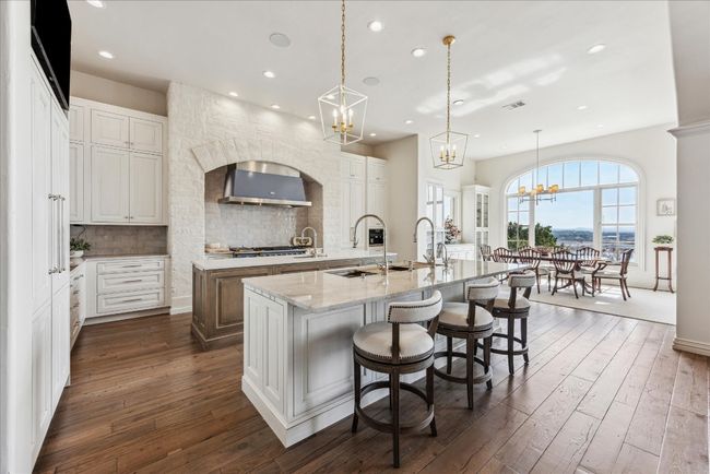 The cook's kitchen offers two islands, breakfast bar and adjacent dining area with lake views. | Image 15