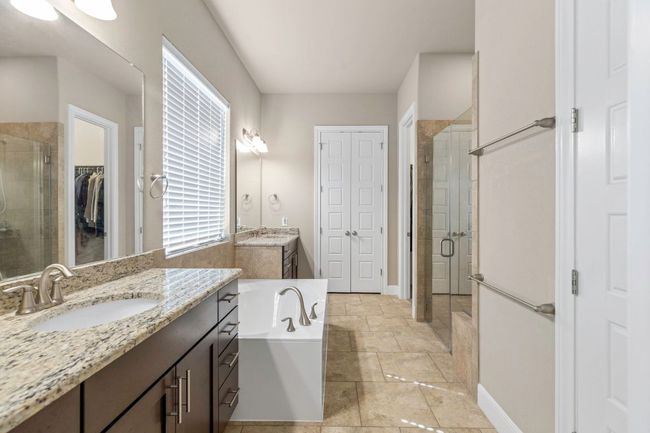Full bath with a stall shower, two vanities, a bath, and a spacious closet | Image 19