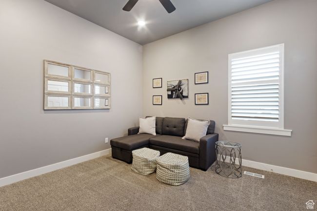 Living area featuring baseboards, a ceiling fan, visible vents, and carpet | Image 18