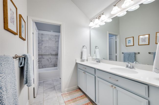 The upstairs full bath features double sinks, a full-length mirror, and a separate shower room—designed for both functionality and privacy. | Image 29