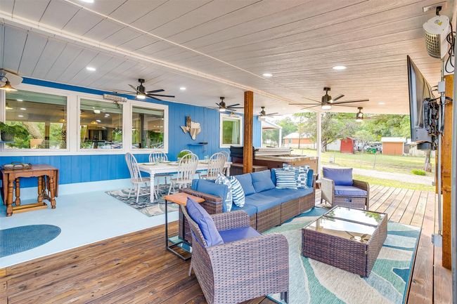 Wooden terrace featuring a ceiling fan, outdoor dining area, and an outdoor living space | Image 5