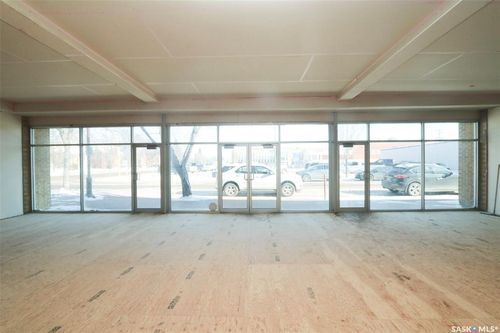 Expansive commercial space featuring a full-width storefront, large windows, and unfinished ceilings | Card Image