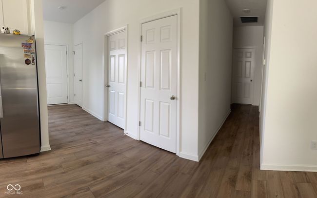 corridor with baseboards, wood finished floors, and visible vents | Image 9