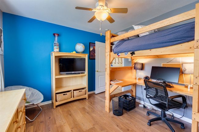 Bedroom featuring an office area, wood finished floors, and baseboards | Image 19