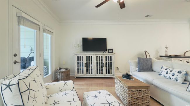 Living area with crown molding, a ceiling fan, and wood finished floors | Image 23