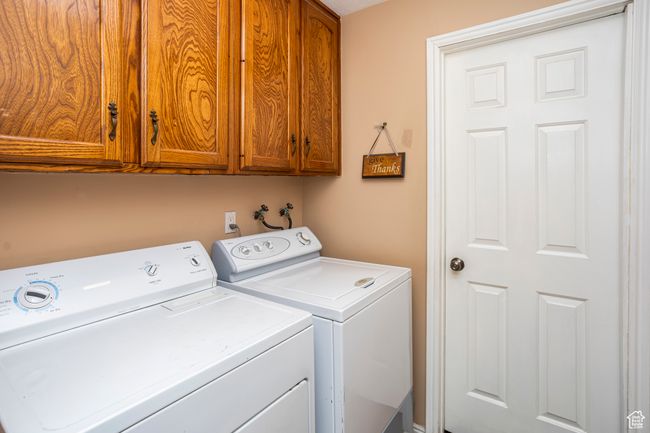 Washroom featuring cabinet space and washing machine and clothes dryer | Image 18