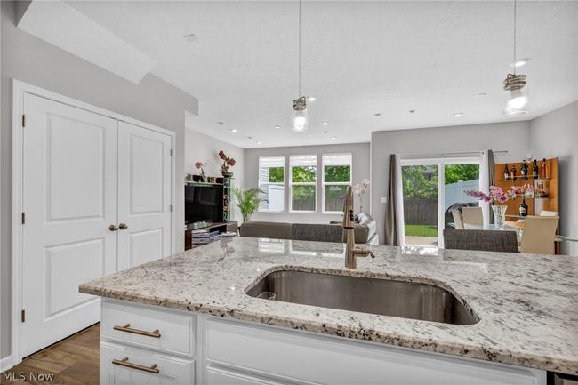Kitchen featuring white cabinetry, plenty of natural light, sink, and pendant lighting | Image 23
