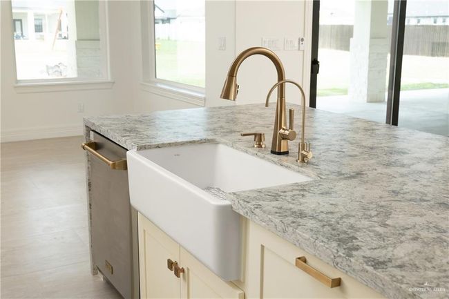 Stylish Kitchen Island with Ceramic SinkAt the heart of the kitchen sits a spacious island featuring a sleek ceramic farmhouse-style sink—a perfect blend of function and elegance. Surrounded by ample counter space and designer fixtures, it’s ideal for food prep, cleanup, and casual gatherings, all while keeping you connected to the living and dining areas. | Image 13