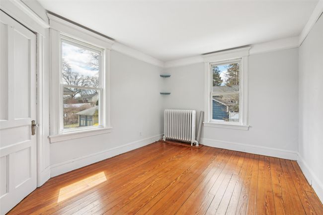 Spare room with radiator heating unit, light wood-style floors, and baseboards | Image 16