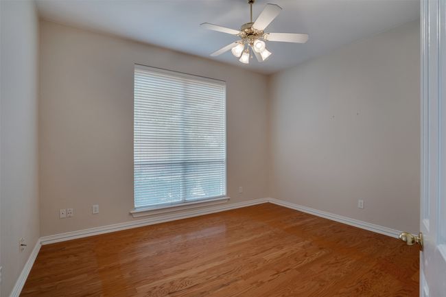 Spare room featuring wood finished floors, baseboards, and a ceiling fan | Image 15