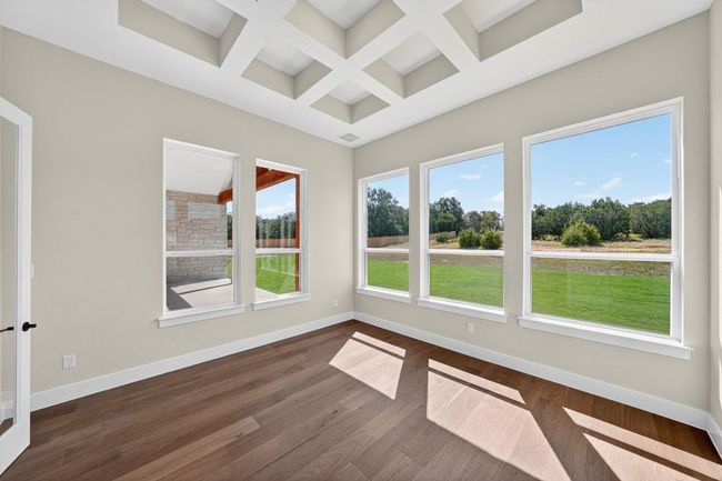 Unfurnished sunroom with coffered ceiling, wood finished floors, and beamed ceiling | Image 10
