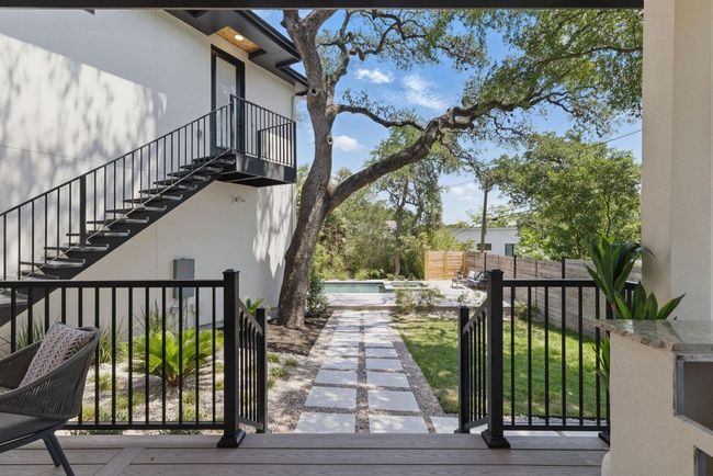 View of side of home with stairs, stucco siding, and fence | Image 32
