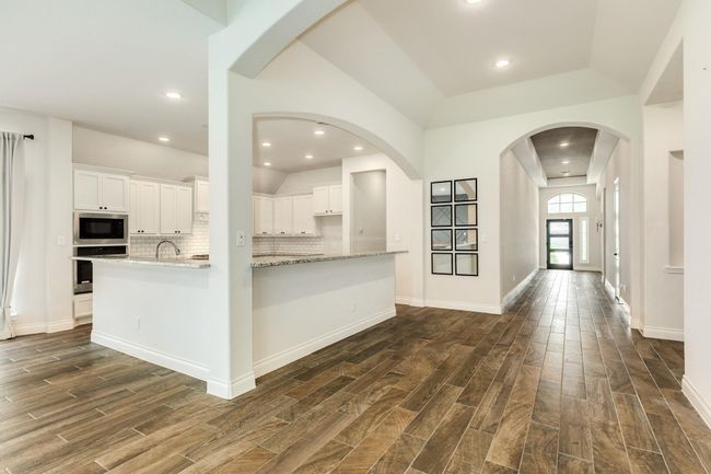 Open floor plan with seamless flow from kitchen to family and dining areas. | Image 15