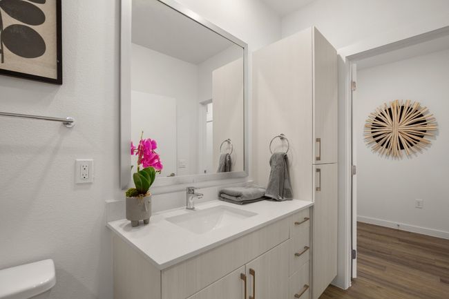 Quartz countertops and vinyl flooring adorn the bathroom | Image 15