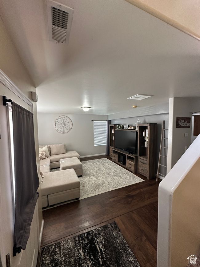 Living area with visible vents and dark wood-style flooring | Image 4