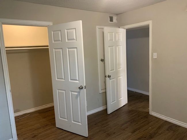 Unfurnished bedroom featuring dark wood-style floors, baseboards, and a closet | Image 7