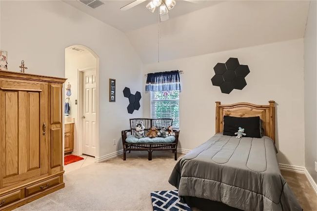 Bedroom with baseboards, arched walkways, vaulted ceiling, ensuite bathroom, and light carpet | Image 24