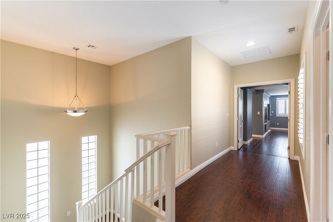 Hall featuring baseboards, visible vents, an upstairs landing, and dark wood-type flooring | Image 22