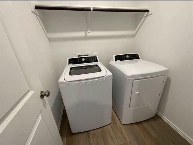 Washroom featuring washer and dryer, wood finished floors, and baseboards | Image 10