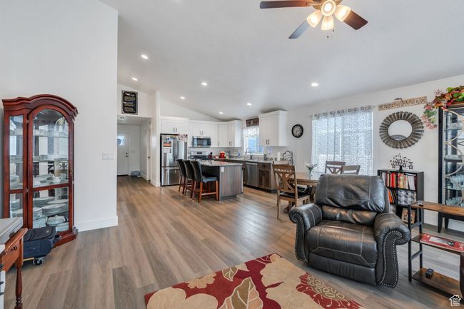 Living area with recessed lighting, ceiling fan, vaulted ceiling, and light wood-type flooring | Image 6