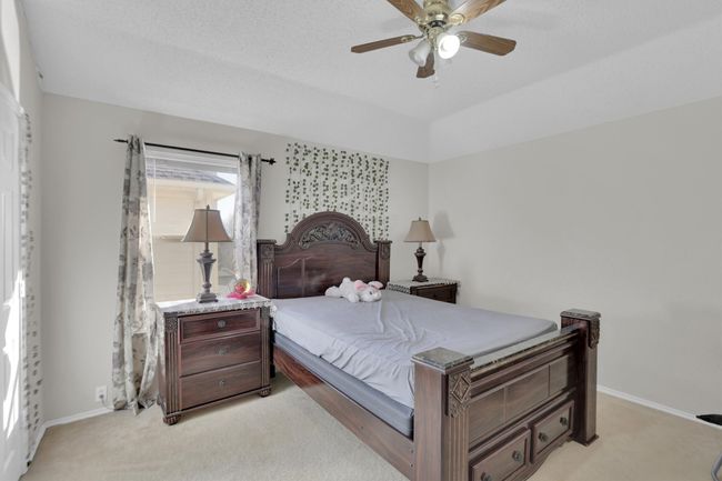 Bedroom with light carpet, ceiling fan, and baseboards | Image 27
