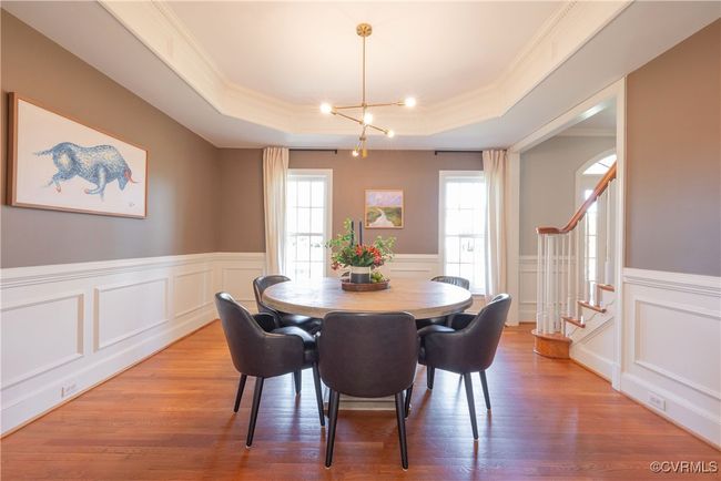 Dining space with a decorative wall, ornamental molding, a raised ceiling, and stairway | Image 14