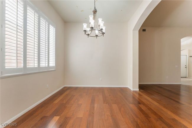 Unfurnished dining area featuring arched walkways, wood finished floors, a chandelier, and healthy amount of natural light | Image 18