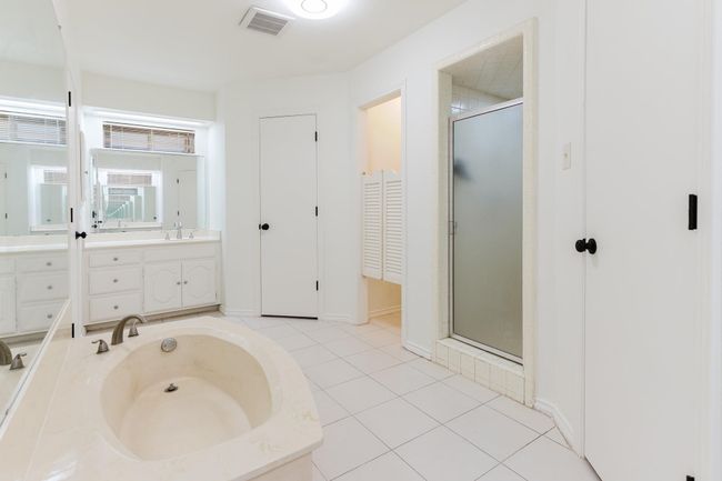 Full bathroom with a stall shower, tile patterned floors, vanity, a garden tub, and visible vents | Image 24