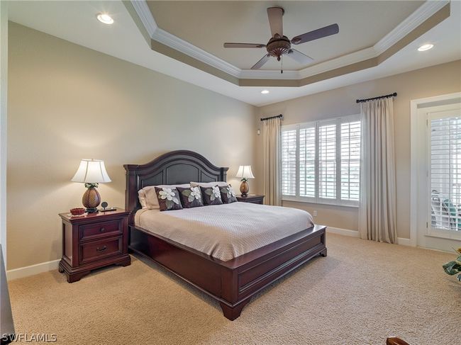 Carpeted bedroom with ceiling fan, a tray ceiling, and ornamental molding | Image 14