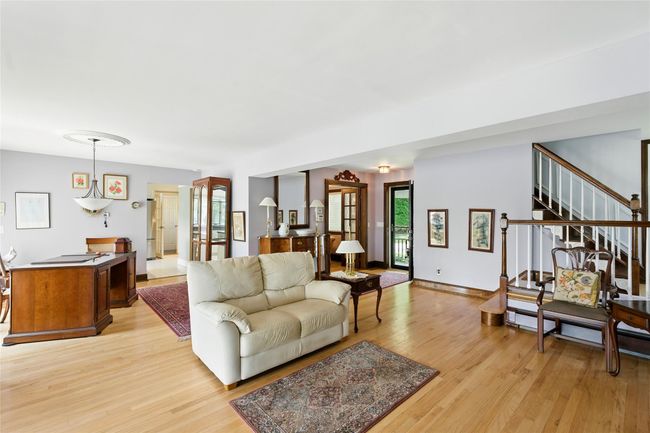Living room featuring light wood-type flooring, plenty of natural light, and stairway | Image 22