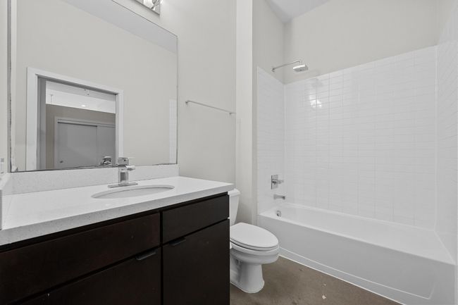Bathroom featuring vanity, shower / bathing tub combination, toilet, and concrete floors | Image 20