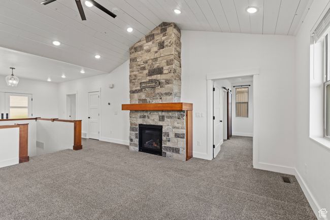 Unfurnished living room with carpet, recessed lighting, a fireplace, baseboards, and ceiling fan | Image 13