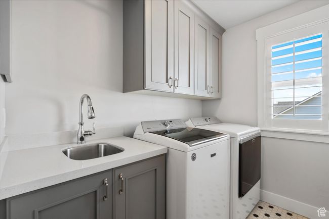 Laundry room with washer and dryer, baseboards, a sink, and cabinet space | Image 37