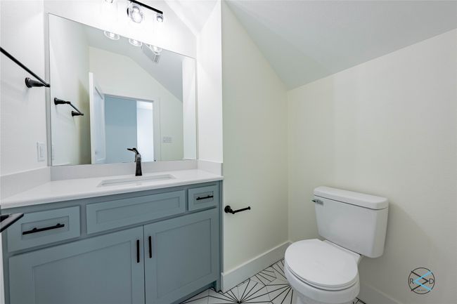Bathroom featuring vaulted ceiling, vanity, and toilet | Image 14