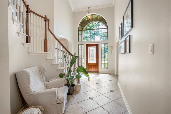 The two-story entry has ample space to receive friends and family, with light reflecting through expansive windows above and next to the entry door. | Image 7