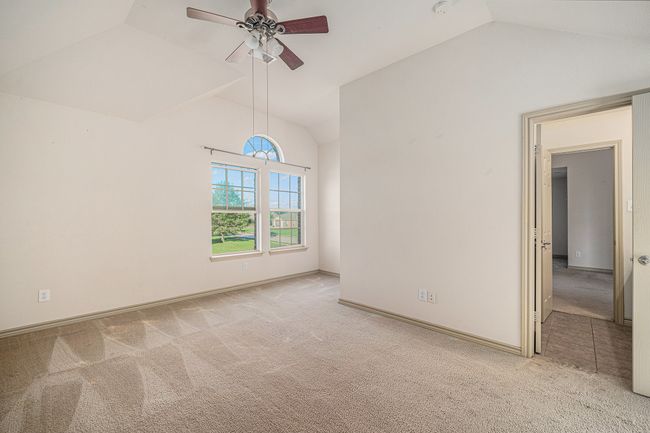 Empty room featuring vaulted ceiling, carpet, a ceiling fan, and baseboards | Image 26