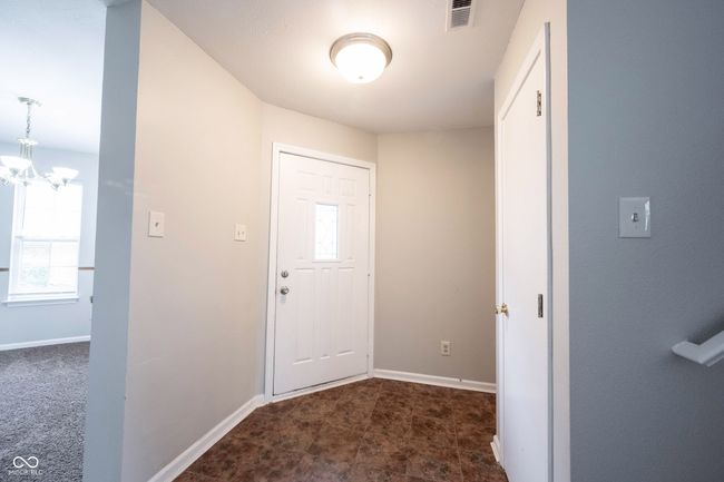 foyer entrance featuring a chandelier, plenty of natural light, visible vents, and baseboards | Image 4