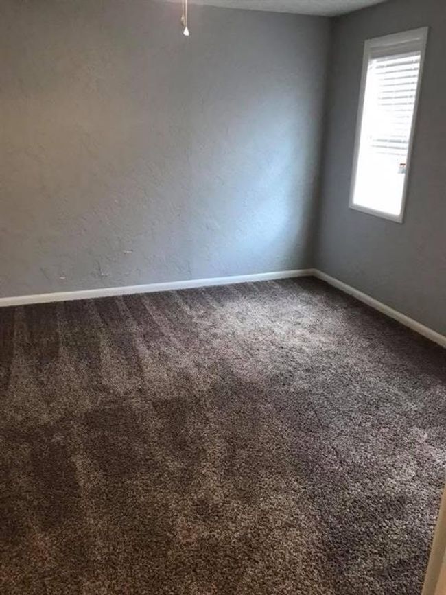 Carpeted empty room featuring a textured wall and baseboards | Image 16