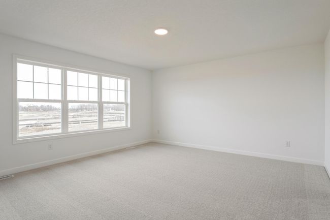 Photo is of the actual home. Extremely spacious and elegant, this private primary suite connects to a large en-suite bath and walk-in closet providing a great oasis to relax in your own private suite. | Image 7