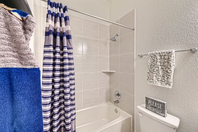 Bathroom featuring shower / tub combo and a textured wall | Image 22