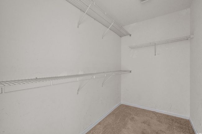Spacious closet featuring light colored carpet | Image 32