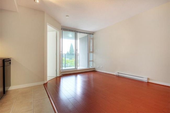 Empty room featuring light wood finished floors, baseboards, and a baseboard radiator | Image 12