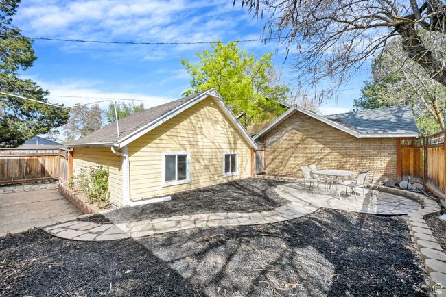 View of side of property featuring a fenced backyard, a patio area, and a shingled roof | Image 26