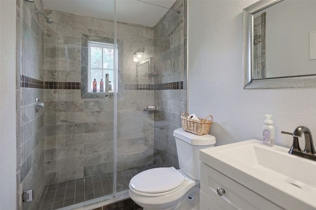 Bathroom with vanity, a stall shower, and toilet | Image 13